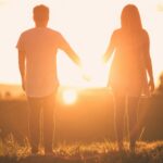 two people in relationship walking into sunset